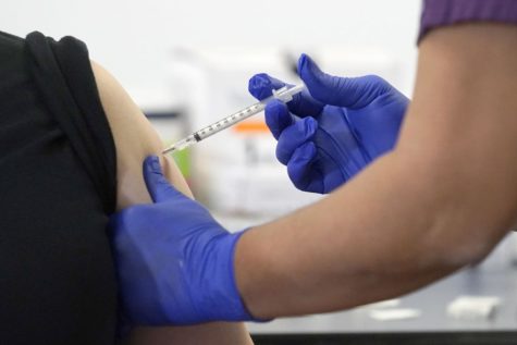 A nurse at Saint Anthony Hospital administers Wednesday, Dec. 23, the first of the two Pfizer-BioNTech COVID-19 vaccinations to a hospital worker at the facility in Chicago. (CHARLES REX ARBOGAST, ASSOCIATED PRESS).




