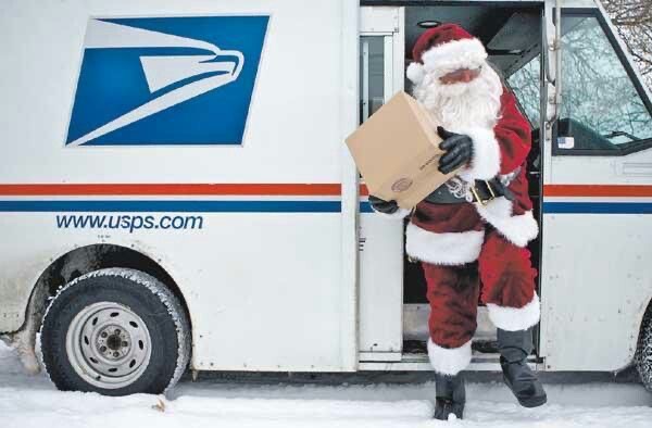 A postal carrier delivers mail dressed as Santa Claus